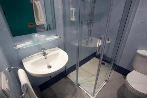 La salle de bains est pourvue d'un lavabo et d'une douche en verre. dans l'établissement Casa Santa Elena, à Santa Cristina d'Aro