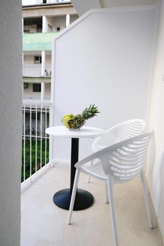 a white table and a chair on a balcony at Zoilo Rooms self check-in in Zadar