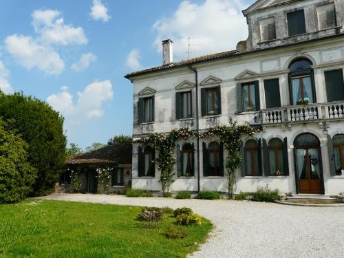 Une vieille maison blanche avec du lierre dessus dans l'établissement Villa Caotorta, à Ponzano Veneto