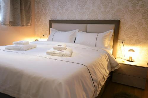 a bedroom with a white bed with towels on it at Zoilo Rooms self check-in in Zadar