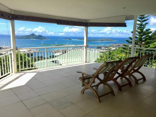a balcony with two chairs and a view of the ocean at Beau Séjour Hotel in Victoria