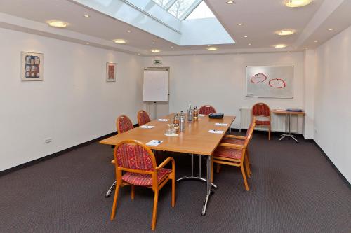 a conference room with a wooden table and chairs at Hotel Bavaria Oldenburg in Oldenburg