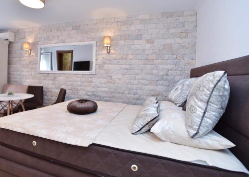 a bedroom with a bed with pillows on it at Old Town Skyline apartment 3 in Budva