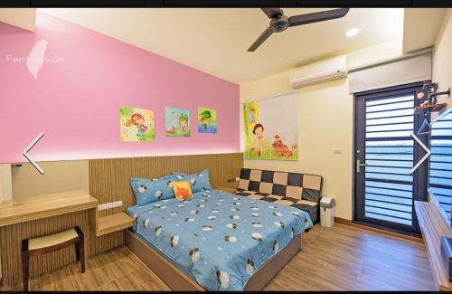 a bedroom with a bed and a pink wall at 澎湖寶貝民宿 in Huxi