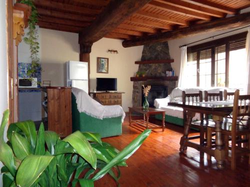 een woonkamer met een tafel en een open haard bij Casas Rurales Casas en Batuecas in Villanueva del Conde