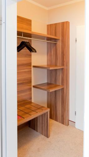a walk in closet with wooden shelves at Hotel Bavaria Oldenburg in Oldenburg