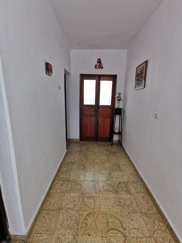 an empty hallway with a door and a tile floor at Casa rural Juan y Juana Canino in Tejeda