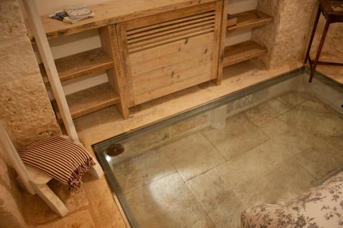 a room with a table and a shelf and a floor at Le Dieci Porte in Alberobello