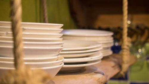 a stack of white plates and bowls on a table at Hostal La Casa De Lili in Salento