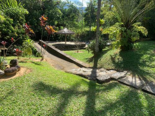 a garden with a shadow of a tree on the grass at Pousada Penedo in Penedo