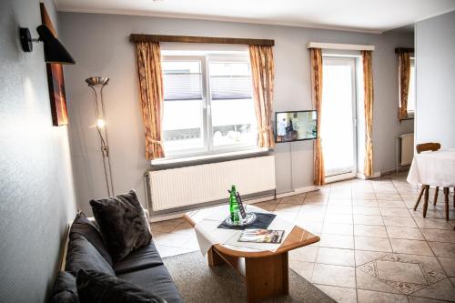 a living room with a couch and a table at Hotel Tum Stüürmann in Büsum