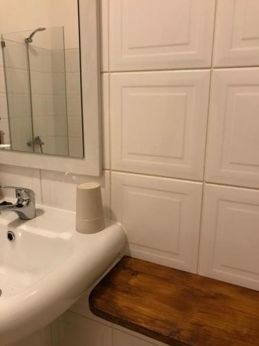 a bathroom with a sink and a mirror and cabinets at Blue Eagle Guesthouse - Casa de hospedes in Santa Maria