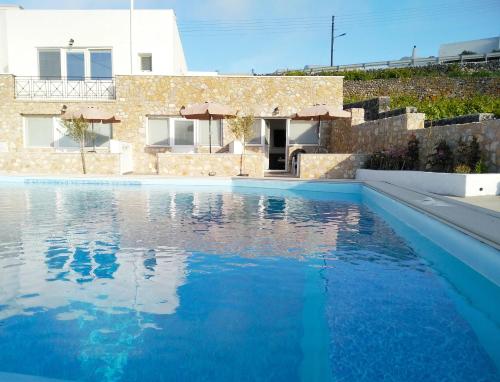 a swimming pool with blue water in front of a house at Aroma Cavas in Pyrgos