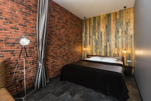 a bedroom with a bed and a brick wall at Loft in Arcadia in Odesa