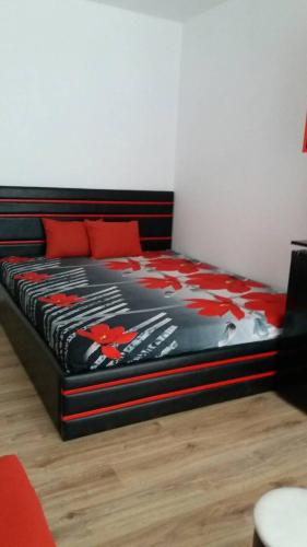 a black bed with red pillows in a room at SUNRISE 3 in Varna City