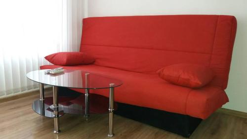 a red couch with red pillows and a glass table at SUNRISE 3 in Varna City