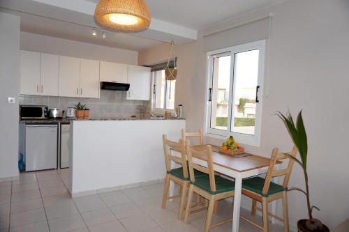 a kitchen with a table and chairs and a counter at Top Seaview Apartment in Peyia in Peyia