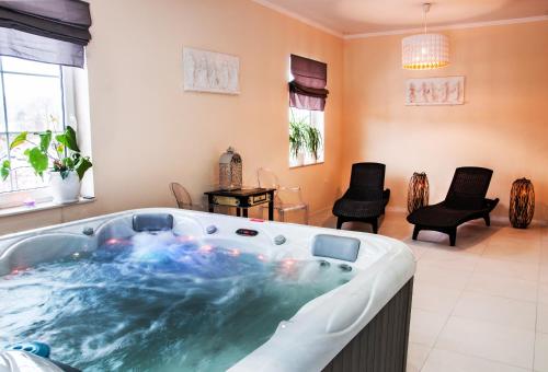 a jacuzzi tub in a living room with chairs at B&B Źródlana 46 in Olszyna