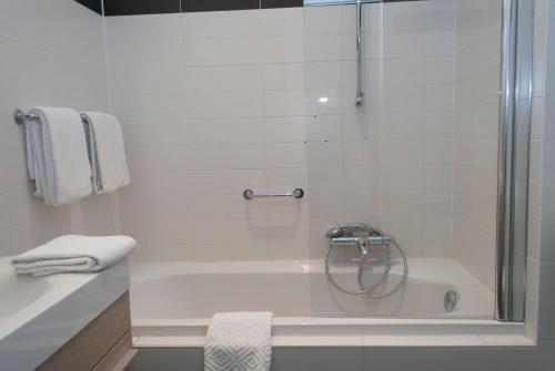 a bathroom with a shower and a bath tub at Hotel Castel in Ghent