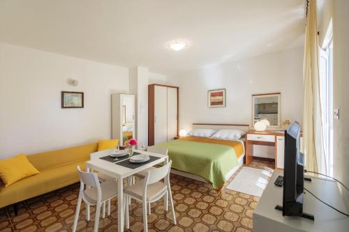 una habitación de hotel con una cama y un sofá en Apartmani Jordana, en Komiža