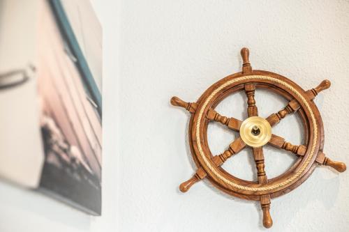 a wooden steering wheel attached to a wall at Hotel Tum Stüürmann in Büsum