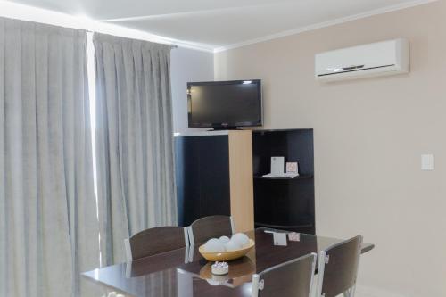 a dining room with a table and a television at Apart Hotel Rivadavia 815 in Neuquén