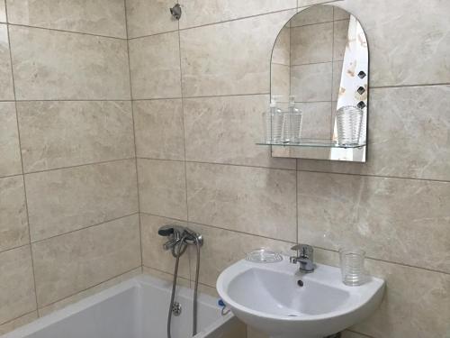 a bathroom with a sink and a mirror and a tub at Адмирал 3. Вилла in Koblevo
