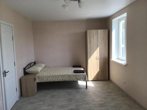 a bedroom with a bed and a cabinet and a window at Адмирал 3. Вилла in Koblevo