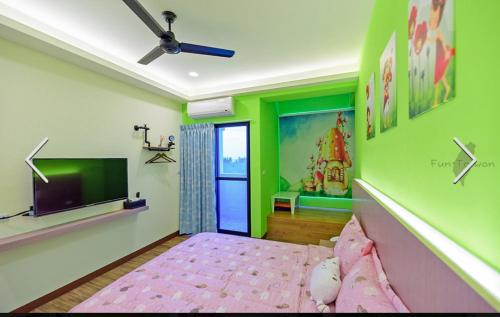 a bedroom with green and pink walls and a tv at 澎湖寶貝民宿 in Huxi