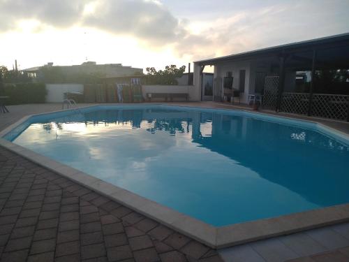 una grande piscina blu di fronte a una casa di B&B Terra Serena a Santa Cesarea Terme