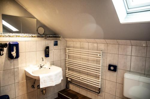 a bathroom with a sink and a toilet at Hotel Tum Stüürmann in Büsum