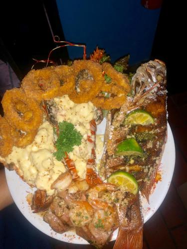 a plate of food with shrimp and onion rings at Hotel Beachfront Vista Hermosa in Jacó