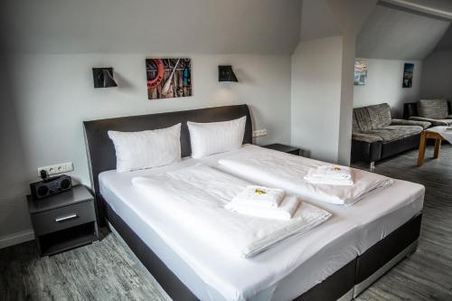 a bedroom with a bed with two towels on it at Hotel Tum Stüürmann in Büsum