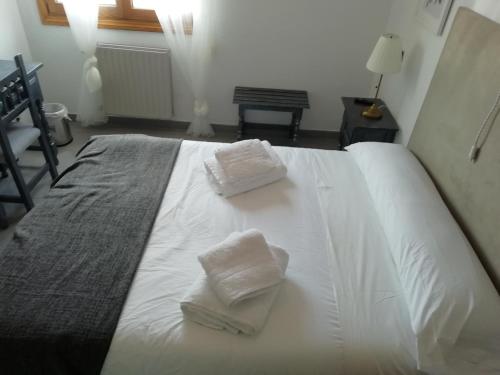a white bed with two towels on top of it at El Sueño del Infante in Guadalajara
