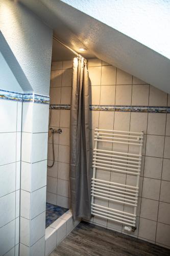 a bathroom with a shower with a shower curtain at Hotel Tum Stüürmann in Büsum