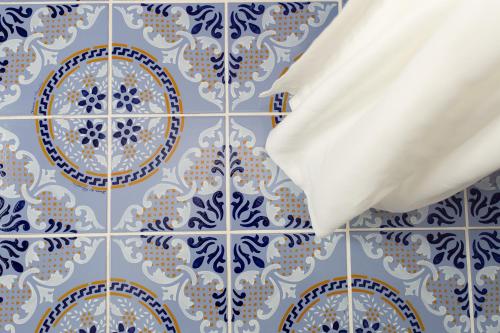 a bathroom with blue and white tiles on a wall at Odysseus Hotel in Lipari