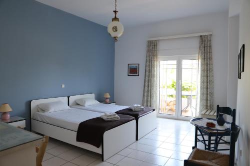 1 dormitorio con cama blanca y pared azul en Aris Apartments, en Gerani