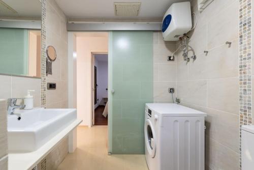 ein Badezimmer mit einer Waschmaschine und einem Waschbecken in der Unterkunft BAJAMAR - renovated apart. nex to the sea in Arucas