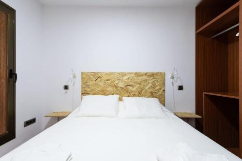 ein Schlafzimmer mit einem großen Bett mit weißer Bettwäsche in der Unterkunft BAJAMAR - renovated apart. nex to the sea in Arucas