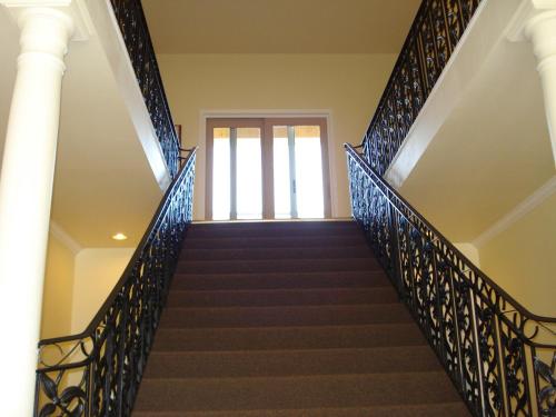 a staircase in a house with blue metal railing at Grey Rose Suites in Hanover