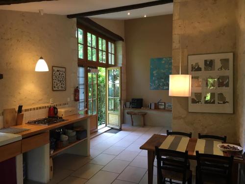une cuisine et une salle à manger avec une table et des chaises dans l'établissement Sous le Tilleul, à Bellon