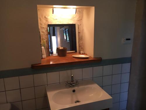 a bathroom with a sink and a mirror at Sous le Tilleul in Bellon