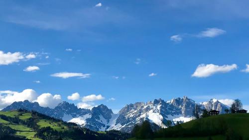 a view of a mountain range with a blue sky at Apartment Hahnenkammblick in Reith bei Kitzbühel