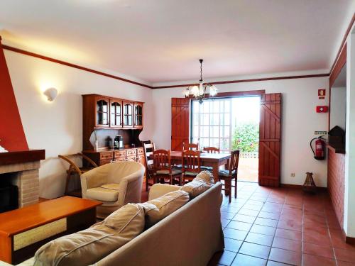 a living room with a couch and a dining room at Space Monte da Rosa in Vila Nova de Milfontes