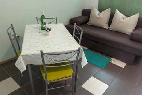 a table and chairs in a living room with a couch at Jovich Apartments 1 in Mošćenička Draga