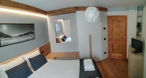 een slaapkamer met een bed en een tv in een kamer bij Casa Zone in Tesero
