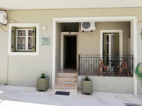 a white house with stairs and a balcony at Maro's Apartments in Argostoli