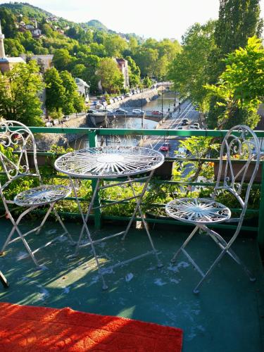 a table and chairs on a balcony with a street at Apartments Emily in Sarajevo