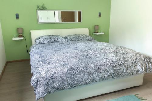 a bedroom with a bed with a gray comforter at Jovich Apartments 1 in Mošćenička Draga