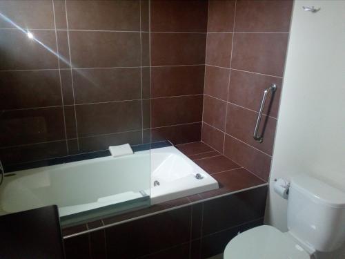 a bathroom with a bath tub and a toilet at Urqu Hotel & Boutique in Jaén